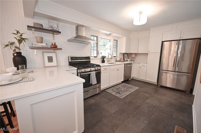 kitchen with wall chimney exhaust hood, sink, white cabinetry, appliances with stainless steel finishes, and kitchen peninsula