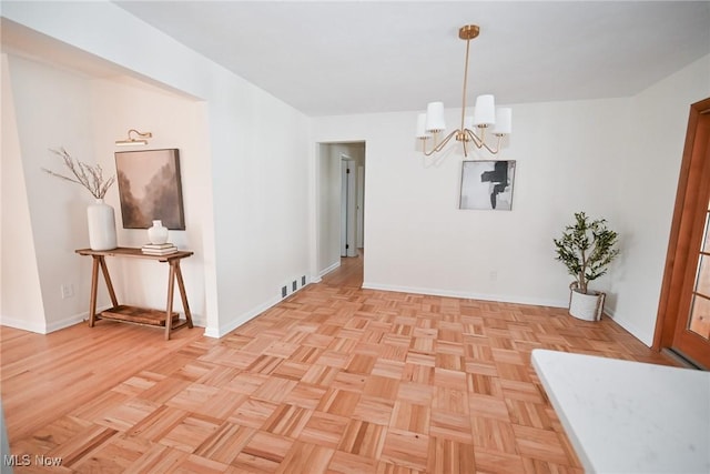 unfurnished dining area featuring an inviting chandelier and light parquet flooring