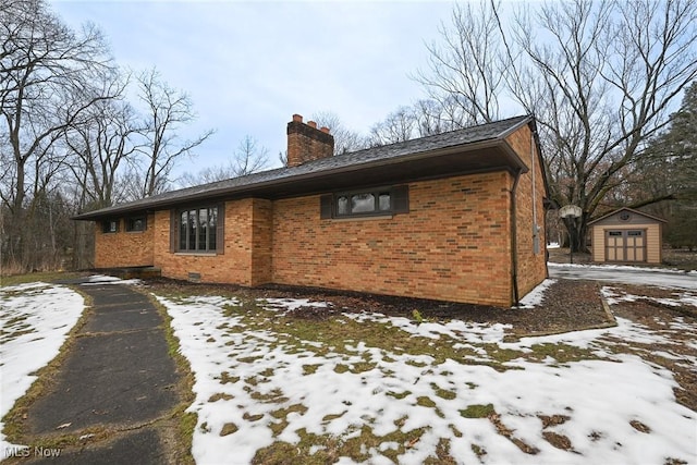 view of snowy exterior with a storage unit