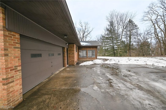 view of snow covered exterior featuring a garage