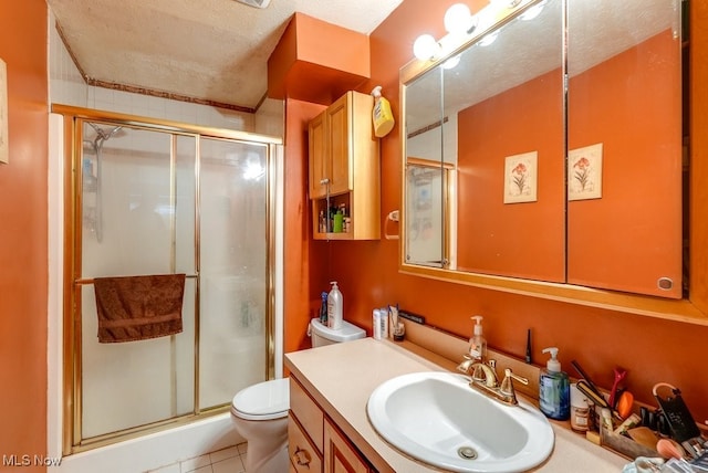 bathroom featuring tile patterned flooring, an enclosed shower, vanity, a textured ceiling, and toilet