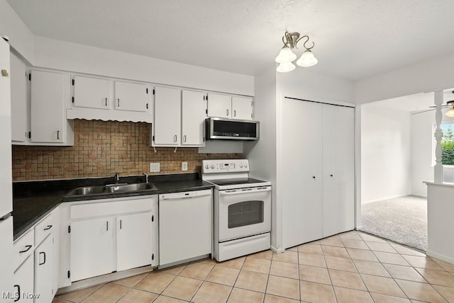9040 Portage Pointe Dr, Streetsboro, OH 44241 - kitchen with white appliances, dark countertops, white cabinets, backsplash, and light tile patterned floors