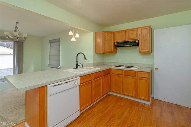 kitchen featuring sink, white appliances, hanging light fixtures, kitchen peninsula, and light wood-type flooring