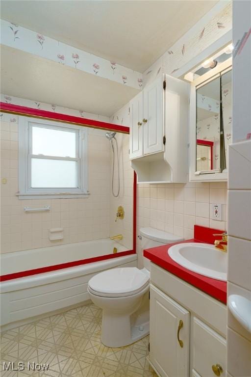 full bathroom with tile walls, vanity, decorative backsplash, toilet, and tiled shower / bath