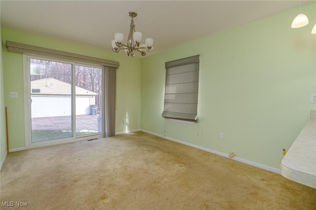 empty room with a notable chandelier and carpet floors