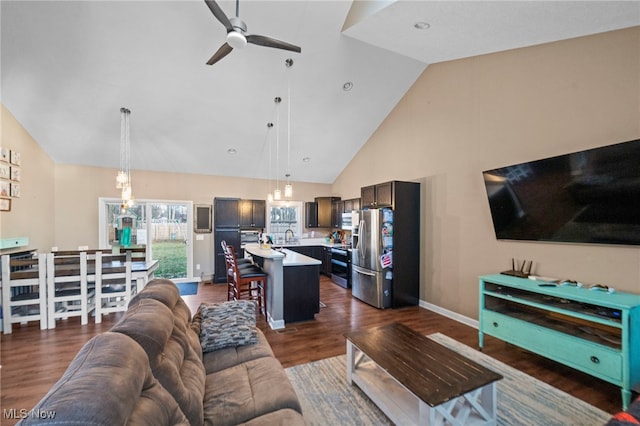 living room featuring dark hardwood / wood-style flooring, high vaulted ceiling, and ceiling fan