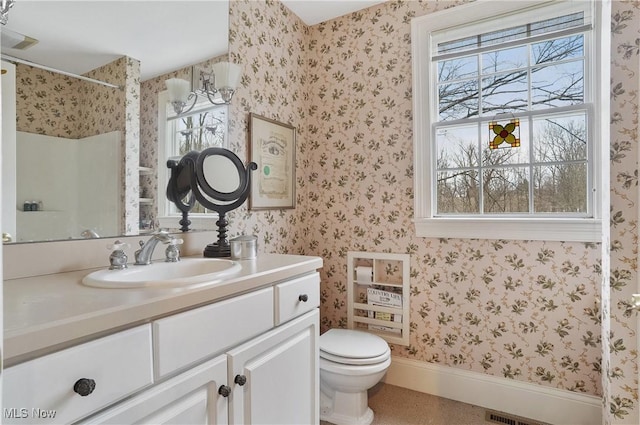 bathroom with vanity, toilet, and a shower