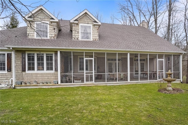 rear view of house with a yard and a sunroom