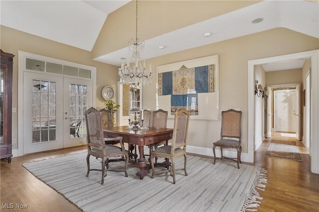 dining area with vaulted ceiling, light wood-type flooring, and french doors