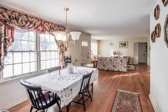 dining area featuring hardwood / wood-style flooring and a notable chandelier