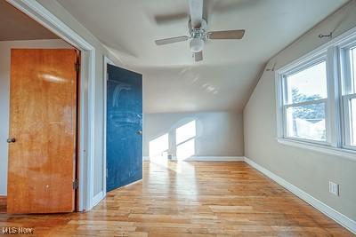 additional living space featuring vaulted ceiling, ceiling fan, and light wood-type flooring