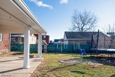 view of yard with a trampoline and a playground