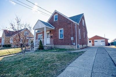 view of front of property featuring a garage, an outbuilding, and a front yard