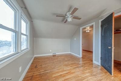 bonus room with ceiling fan, plenty of natural light, vaulted ceiling, and light wood-type flooring