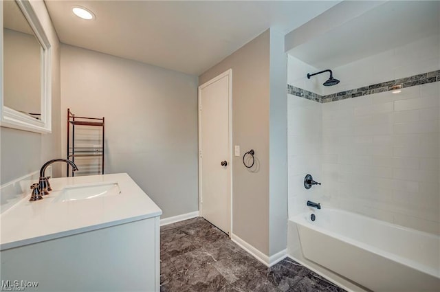 bathroom with tiled shower / bath and vanity