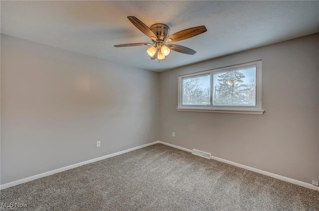 carpeted empty room featuring ceiling fan and a textured ceiling