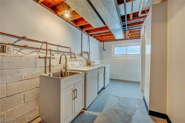 clothes washing area with cabinets, sink, and washer and clothes dryer