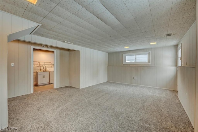 basement with washing machine and clothes dryer and carpet