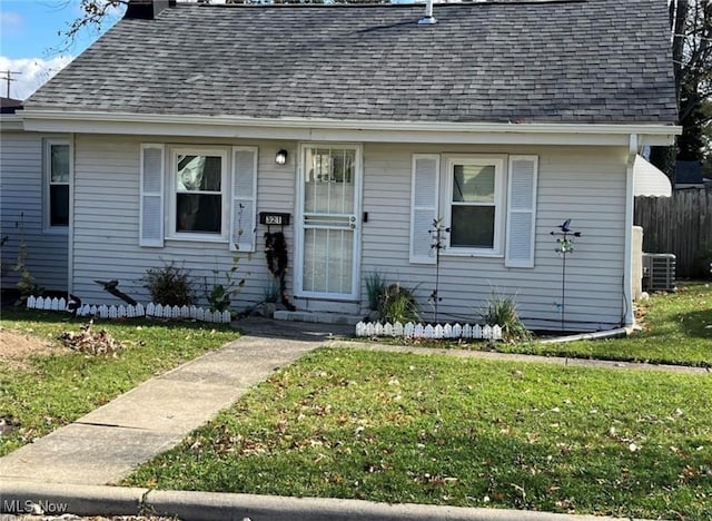 bungalow-style house featuring a front yard and central air condition unit