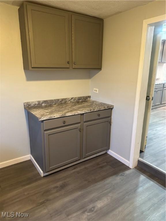 interior space featuring gray cabinets, dark hardwood / wood-style floors, and a textured ceiling