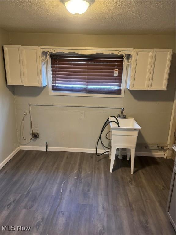 laundry area with washer hookup, cabinets, dark hardwood / wood-style floors, and a textured ceiling