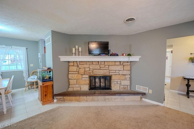 living room with light carpet, a stone fireplace, and a textured ceiling