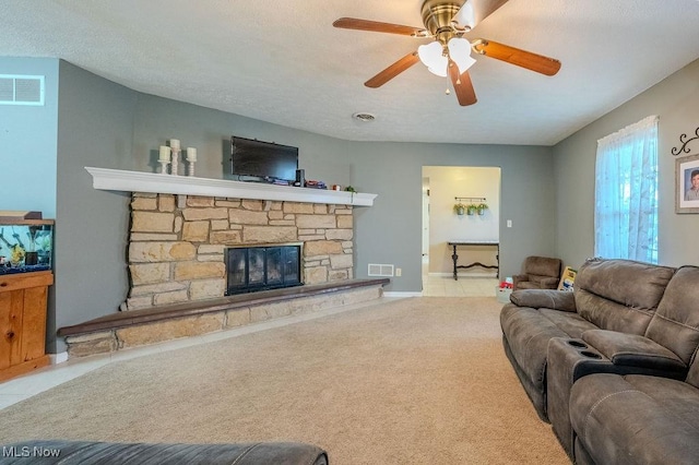 living room featuring light carpet, a fireplace, and ceiling fan