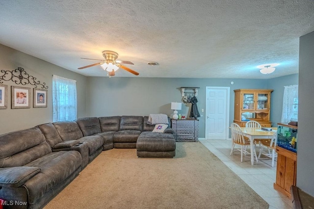 living room with light tile patterned floors, a textured ceiling, and ceiling fan