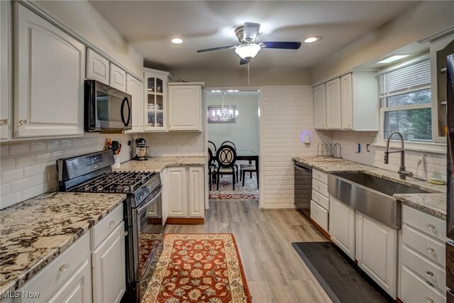 kitchen with white cabinetry, light stone countertops, and black appliances