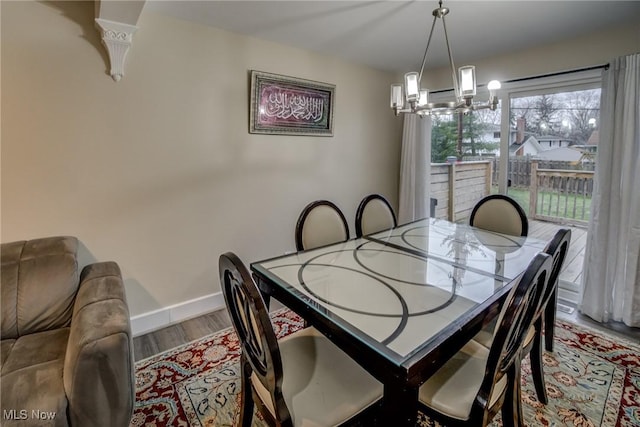 dining area with hardwood / wood-style flooring and a notable chandelier