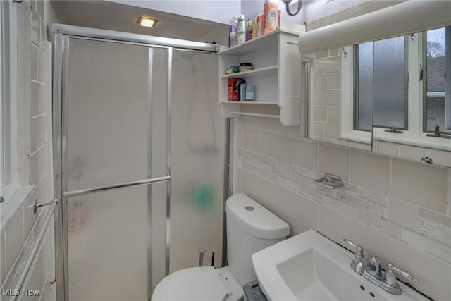 bathroom featuring an enclosed shower, sink, backsplash, and tile walls