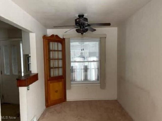 unfurnished dining area with carpet flooring and ceiling fan