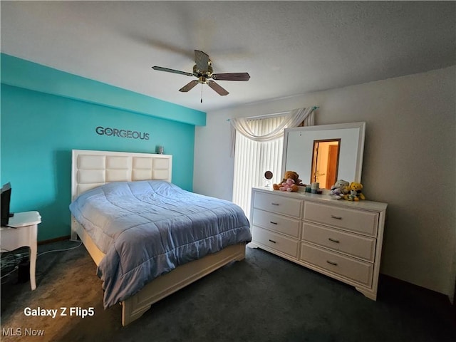 bedroom with dark colored carpet and ceiling fan