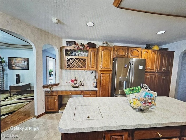 kitchen featuring tasteful backsplash, stainless steel fridge with ice dispenser, and a kitchen island