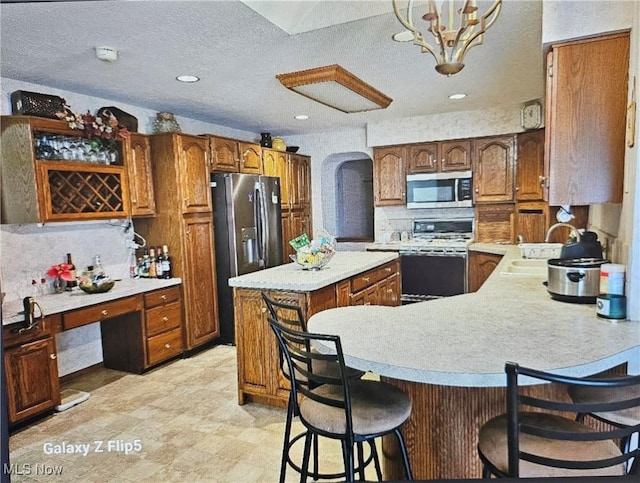 kitchen featuring stainless steel appliances, sink, a breakfast bar area, and backsplash