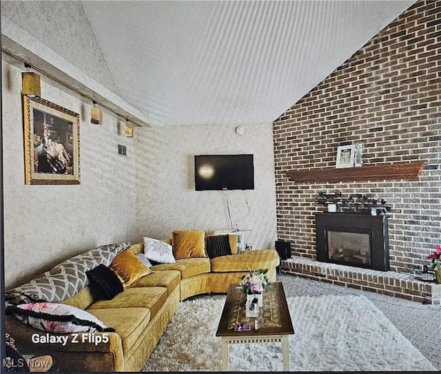 living room with vaulted ceiling and a brick fireplace