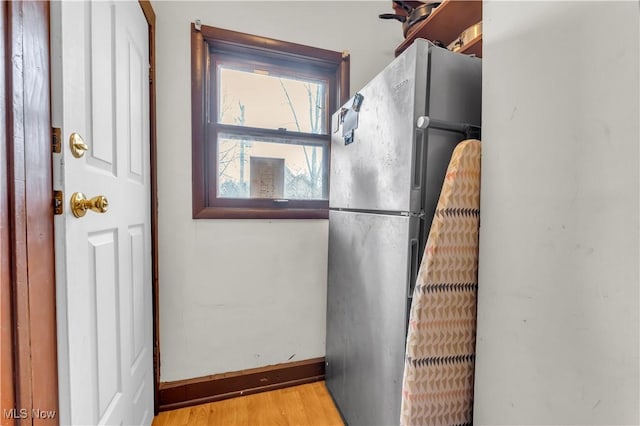 kitchen with stainless steel refrigerator and light hardwood / wood-style flooring