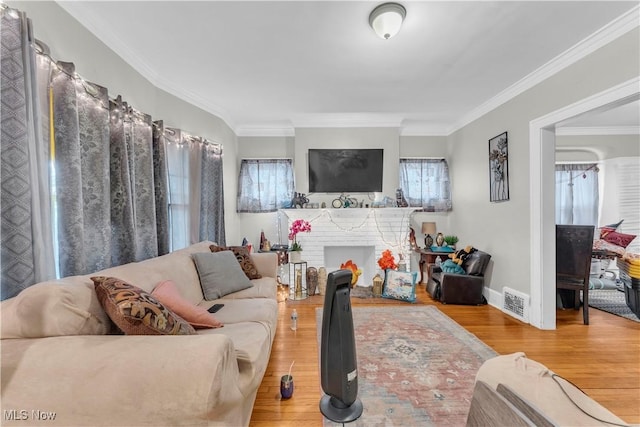 living room with a fireplace, ornamental molding, and wood-type flooring