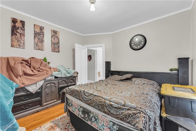 bedroom featuring ornamental molding and hardwood / wood-style floors