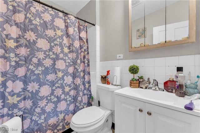 bathroom with vanity, tile walls, and toilet