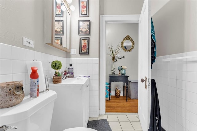 bathroom with vanity, tile walls, tile patterned floors, and toilet