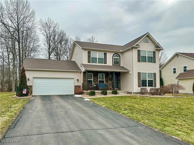 view of front property with a porch, a garage, and a front lawn