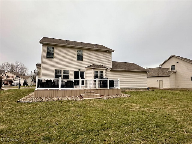 rear view of house with a deck and a lawn