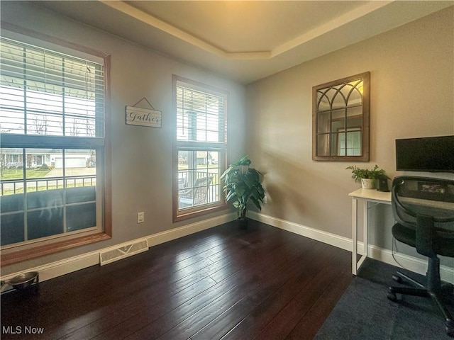 office featuring dark hardwood / wood-style floors and a raised ceiling