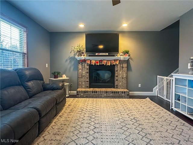 living room with recessed lighting, a fireplace, baseboards, and wood finished floors