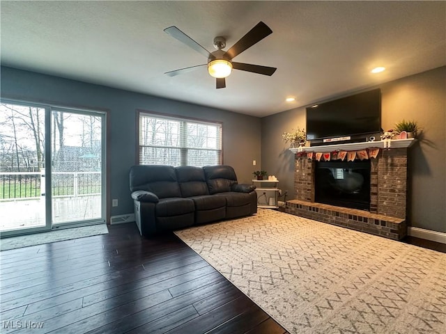 living room featuring baseboards, a ceiling fan, wood-type flooring, a fireplace, and recessed lighting