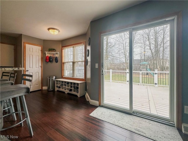 doorway featuring dark wood finished floors and baseboards