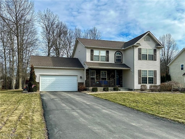 traditional home with an attached garage, covered porch, driveway, and a front yard