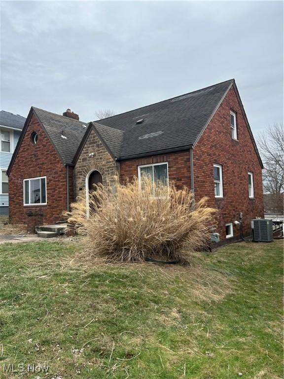 view of front of house featuring central AC unit and a front yard