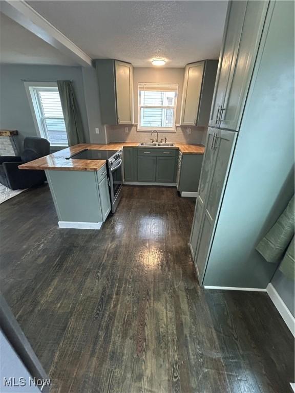 kitchen featuring sink, gray cabinetry, butcher block counters, electric range, and dark hardwood / wood-style floors